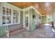 Relaxing covered porch with a swing, rocking chairs, and a wood plank ceiling at 324 Wendover Hill Ct, Charlotte, NC 28211