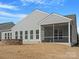 Back exterior view showing gray siding, patio, screened-in porch, and fire pit at 4030 Ambleside Dr, Fort Mill, SC 29707