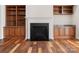 Living room fireplace with built-in bookshelves and wood flooring at 4030 Ambleside Dr, Fort Mill, SC 29707