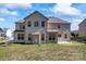 Exterior view of the back of a two-story home, showing the yard at 4435 Mill Landing Dr, Harrisburg, NC 28075