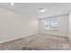 Neutral carpeted bedroom with a window view and a flush mount ceiling light at 4435 Mill Landing Dr, Harrisburg, NC 28075