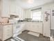 Bright kitchen featuring white cabinets, appliances, grey backsplash and tile flooring at 4455 Hampton Rd, Salisbury, NC 28144