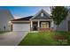 Charming single-story home with stone accents, a manicured lawn, and a two-car garage at 447 Zender Ln, Monroe, NC 28112
