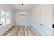 Bright dining room featuring wood-look flooring, a modern chandelier, and a large window at 5311 Meadowland Pkwy, Monroe, NC 28112