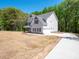 Stunning two-story home with an attached garage and a long driveway, surrounded by nature and landscaping at 5311 Meadowland Pkwy, Monroe, NC 28112