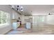 Open-concept kitchen with granite counters, stainless appliances, white cabinetry, and wood-look flooring at 5311 Meadowland Pkwy, Monroe, NC 28112