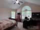Comfortable bedroom featuring vaulted ceilings, a ceiling fan, natural lighting, and office space at 5518 Prosperity View Dr, Charlotte, NC 28269