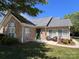 Charming home features a stone facade, well-kept lawn, and inviting front porch seating area at 5518 Prosperity View Dr, Charlotte, NC 28269