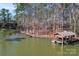 Aerial view of a covered boat dock and lakefront property surrounded by trees at 693 Emerald Shores Rd, Mount Gilead, NC 27306