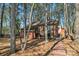 Brick home featuring a deck and patio, surrounded by mature trees at 693 Emerald Shores Rd, Mount Gilead, NC 27306