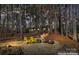 A lakeside view with Adirondack chairs and a fire pit provides a cozy outdoor retreat at dusk at 693 Emerald Shores Rd, Mount Gilead, NC 27306