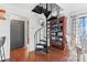 Elegant living room showcasing hardwood floors, a spiral staircase, and a built-in bookshelf at 693 Emerald Shores Rd, Mount Gilead, NC 27306
