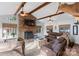 Spacious living room with a stone fireplace, beamed ceilings, and comfortable leather furniture at 693 Emerald Shores Rd, Mount Gilead, NC 27306