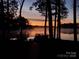 Dock at sunset featuring serene lake views and peaceful atmosphere at 693 Emerald Shores Rd, Mount Gilead, NC 27306