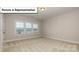 Spacious bedroom featuring neutral carpet, trim, and paint, and a large window at 7009 Sylvan Retreat Dr, Denver, NC 28037