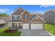 Charming two-story home with a stone facade and a two-car garage, nestled in a well-manicured community at 7027 Sylvan Retreat Dr, Denver, NC 28037