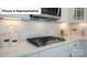 Well-appointed kitchen features white cabinetry, quartz countertops, and stainless steel gas cooktop at 7027 Sylvan Retreat Dr, Denver, NC 28037