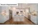 Open-concept kitchen boasts white cabinets, stainless steel appliances, and a large island with bar stool seating at 7027 Sylvan Retreat Dr, Denver, NC 28037