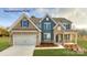 Charming two-story home with a stone facade, attached garage, and well-manicured lawn at 7033 Sylvan Retreat Dr, Denver, NC 28037