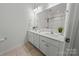 Modern bathroom with double vanity, white countertops and cabinets, and a large mirror at 7127 Chrysanthemum Rd, Lancaster, SC 29720