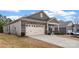 Single-Gathering home showcasing a two-car garage, stone accents, and a well-manicured front yard at 7127 Chrysanthemum Rd, Lancaster, SC 29720