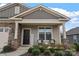 Inviting covered porch with comfortable seating, stone pillars, and a welcoming entryway at 7127 Chrysanthemum Rd, Lancaster, SC 29720