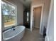 Relaxing bathroom features soaking tub next to a large window and glass-enclosed walk-in shower at 7459 Fighting Creek Rd # 33, Sherrills Ford, NC 28673