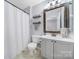 Clean bathroom design with neutral colors, shower with curtain and single sink vanity at 8004 Sapwood Ct, Matthews, NC 28104