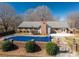 Private backyard with a large covered pool surrounded by a brick fence and manicured landscaping at 102 3Rd Se Ave, Catawba, NC 28609