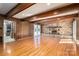 Living room with stone fireplace, wood beams, hardwood floors, and paneled walls at 102 3Rd Se Ave, Catawba, NC 28609