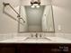 Stylish bathroom vanity with granite countertop, modern faucet, and well-lit mirror at 1146 Crestmont Se Dr, Concord, NC 28025