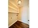 A bright and functional laundry room boasts built-in shelving, wood-look flooring, and utility hookups at 1146 Crestmont Se Dr, Concord, NC 28025