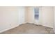 Clean bedroom with white walls, carpeted flooring, and window for soft natural light at 11918 Crabapple Ln, Huntersville, NC 28078
