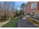 Beautiful backyard featuring a brick home, tiered landscaping, and a black iron fence at 1301 Charter Pl, Charlotte, NC 28211