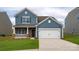 Charming two-story home with blue siding, brick accents, and a well-manicured lawn at 1348 Secrest Commons Dr, Monroe, NC 28112