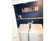 Laundry area with a front-load washer and dryer, open shelf, and 