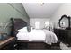 A well-lit main bedroom featuring a tufted headboard and neutral decor, bathed in natural light from two windows at 14312 Evening Flight Ln, Charlotte, NC 28262