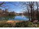 Peaceful lake featuring a fountain in the middle of the lake and residential buildings in the background at 14312 Evening Flight Ln, Charlotte, NC 28262