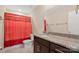 The bathroom has a granite countertop vanity, dark cabinets and a red shower curtain at 147 Stanfield Farm Ln, Stanfield, NC 28163