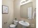 Cozy half bathroom with a pedestal sink, toilet, and a decorative print on the wall at 147 Stanfield Farm Ln, Stanfield, NC 28163
