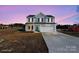 Two story home with grey and white siding, shutters, a blue front door, and a two car garage at 147 Stanfield Farm Ln, Stanfield, NC 28163