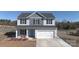 Two story home with grey and white siding, shutters, a blue front door, and a two car garage at 147 Stanfield Farm Ln, Stanfield, NC 28163