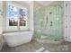 Luxurious bathroom with a freestanding tub, glass shower enclosure, and a large window for natural light at 154 Fox Hunt Dr, Mooresville, NC 28117