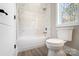 Clean and modern bathroom featuring white tile, a tub-shower combo, and wood-look flooring at 154 Fox Hunt Dr, Mooresville, NC 28117