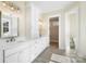 Bright bathroom featuring double vanity, white cabinets, modern fixtures, and a doorway to a walk-in closet at 154 Fox Hunt Dr, Mooresville, NC 28117