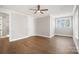 Neutral bedroom featuring hardwood flooring, white trim, and a large window for natural lighting at 154 Fox Hunt Dr, Mooresville, NC 28117