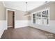 Elegant dining room featuring wainscoting, wood floors, and a modern chandelier, with an open doorway at 154 Fox Hunt Dr, Mooresville, NC 28117