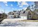 Beautiful exterior view of a light blue two-story home with three-car garage and a long concrete driveway at 154 Fox Hunt Dr, Mooresville, NC 28117