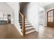 Inviting foyer with hardwood floors, staircase with dark metal railings, and views into the kitchen at 154 Fox Hunt Dr, Mooresville, NC 28117