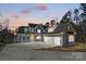 Stunning front exterior featuring a well-lit driveway and a three car garage at dusk at 154 Fox Hunt Dr, Mooresville, NC 28117
